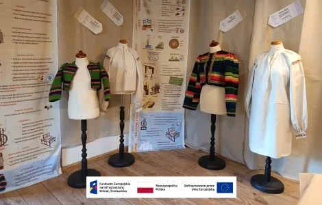 cztery manekiny ubrane w stroje ludowe, w tle plansze informacyjne dotyczące tkanin i materiałów 